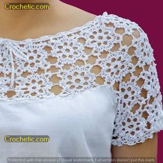 the back of a woman's white top with crocheted lace on it