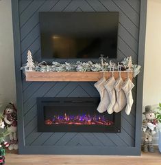 a fireplace with stockings hanging from it's sides and christmas decorations on the mantle