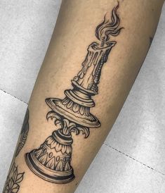 a tattoo on the leg of a person with a bell