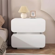 a white nightstand sitting next to a bed in a bedroom