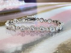 "Elevate your jewelry game with this stunning 925 Sterling Silver Round Brilliant Cut Cubic Zirconia Halo Tennis Bracelet. Crafted from high-quality .925 solid sterling silver, this bracelet exudes luxury and sophistication. With a 7\" inch length and a 7.5mm width, this bracelet is the perfect statement piece to add to any outfit. The box lock with double safety closure ensures that this bracelet stays securely on your wrist, giving you peace of mind while wearing it. The anti-tarnish coating on the silver ensures that the bracelet stays shiny and lustrous for years to come. Featuring AAA cubic zirconia stones, this bracelet sparkles and shines just like real diamonds. The halo design adds an elegant touch, making this bracelet perfect for any occasion. Pair it with a little black dress f Palm Cuff, Cz Bracelet, Halo Design, Luxury Diamonds, Hand Chain, Gold Bracelet Chain, Statement Bracelet, Cz Diamond, Tennis Bracelet