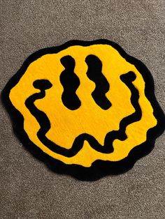 a black and yellow rug with a smiley face drawn on it's center piece