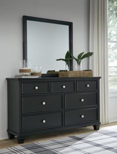 a black dresser and mirror in a room