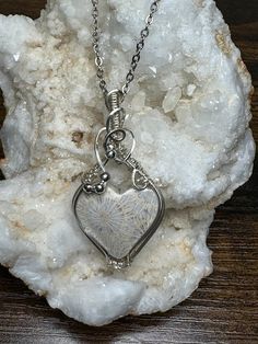 This beautiful detailed fossil coral heart pendant is roughly 2" tall and 1" wide, it comes with a complimentary 18" stainless steel chain, and in a gift box, ready for gifting!  These are not costume pieces that will chip away or rust over time. They will last forever if taken care of, which is why I include a free polishing cloth with every order.  All of my pieces are made with high quality wire from Rio Grande. Quality is very important to me.       If you have any questions, message me, I'm happy to help. Artisan Silver Heart Pendant Necklace, Spiritual Handmade Jewelry With Heart Pendant, Wire Wrapped Jewelry For Valentine's Day Anniversary, Artisan Jewelry With Heart Charm As Gift, Artisan Jewelry With Heart Charm For Gift, Valentine's Day Wire Wrapped Jewelry For Anniversary, Handmade White Stainless Steel Jewelry, Artisan Sterling Silver Heart Pendant Jewelry, Handmade Sterling Silver Heart Pendant Jewelry