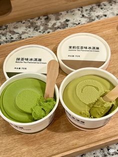 three ice creams with green tea in them on a wooden tray next to some chinese writing