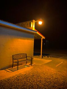 a bench sitting next to a building under a street light