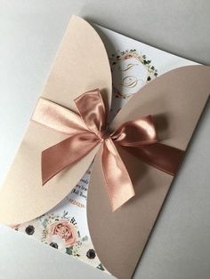 an open card with a bow on the front and inside of it, sitting on top of a table