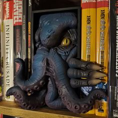 an octopus statue sitting on top of a bookshelf next to several other books