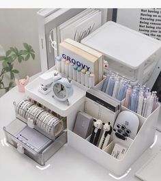 an organized desk with pens, pencils, and other office supplies on top of it