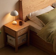 a bed with a wooden headboard and night stand next to a lamp on the nightstand