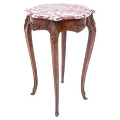 an antique wooden table with marble top