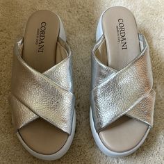 Super Comfortable And Versatile Quality Sandal By Cordani. Criss Crossed Pebble Upper Lining . White Bottom, Padded Footbed. Never Worn, Brand New, Box Included Heel Height- 2 1/2" Platform - 1 3/4" Silver Footbed Sandals With Removable Insole And Round Toe, Silver Leather Slides With Cushioned Footbed, Silver Cushioned Slip-on Sandals, Silver Open Toe Mules With Removable Insole, Silver Slides With Leather Footbed, Silver Slip-on Sandals With Leather Footbed, Metallic Leather Sandals With Cushioned Footbed, Silver Slides With Cushioned Footbed And Round Toe, Silver Open Toe Slides With Cushioned Footbed