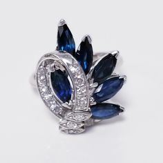 a brooch with blue and white stones in the shape of an oval, surrounded by diamonds