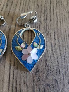 "Vintage 1980's Earrings Alpaca Mexico - Signed Dangle Style Clip On Closure Tear Drop Shape Blue Resin and Mother of Pearl Inlay Flower Design 1.5\" Tall Very Nice Condition - No issues to disclose - Ships Promptly and with care. Please keep in mind that this is a vintage item. It has been pre-loved & is likely not in perfect new condition but certainly wearable and ready to enjoy. Look at all photos carefully as they are part of the description. All Sales are Final. No Refunds or returns. Vintage Blue Flower Earrings, Vintage Nickel-free Teardrop Clip-on Earrings, Vintage Blue Flower Earrings, Nickel-free, Vintage Blue Flower Earrings Nickel Free, Vintage Teardrop Nickel-free Clip-on Earrings, Blue Vintage Flower Earrings Nickel-free, Nickel-free Teardrop Vintage Clip-on Earrings, Vintage Blue Flower Drop Earrings, Vintage Blue Handmade Flower Earrings