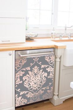 a dishwasher sitting inside of a kitchen next to a window