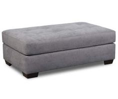 a large gray ottoman with wooden legs and footrests on an isolated white background