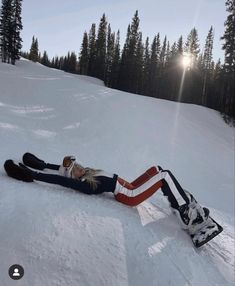 a woman laying in the snow on her back