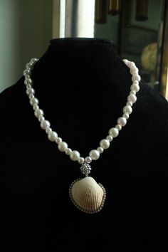 Embrace the summer sun in true style with the Mystic Tides Pendant Necklace! This beauty comes in a pristine white color that instantly lends your look luxury and an ethereal vibe, featuring alternate big and small faux pearls that are complemented with a sphere charm to truly form a look of whimsy and wonder. Rhinestone embellished seashell is sure to brighten up your sunny days. Pair with strapless dresses! Screw Barrel Clasp Closure Material: Faux Pearl Beads, Real Seashell, Elastic String Elegant Pearl Drop Necklace For Summer, Summer Pearl Pendant Jewelry, Elegant Shell Necklace For Summer Vacation, Elegant Summer Shell Necklace For Vacation, Elegant Pearl Pendant Shell For Beach, Summer Pearl Strand Jewelry, Elegant Shell Strand Necklace For Summer, Summer White Necklace With Pearl Pendant, Elegant Shell Necklaces For Summer