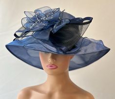 The featured hat is a navy blue organza hat with a dramatic design. The design has a soft  bunch of organza petals in navy blue atop a very large crinoline bow with satin edges.   This  one of a kind hat by Letty is very stylish and chic. This special hat has an Audrey Hepburn style look to it. This hat will be perfect for Church  or  for the Kentucky Derby ,Tea Party, Wedding Party, Easter hat, Downton Abby hat and any other special  occasion. Brim: 4" Rise: 3.5" Size:  22" Fitted Navy Hat For Kentucky Derby, Elegant Navy Hat For Evening, Elegant Navy Wide Brim Hat, Navy Hat For Kentucky Derby Party, Navy Party Hat For Kentucky Derby, Elegant Navy Hats With Curved Brim, Elegant Navy Hat With Curved Brim, Blue Cloche Hat For Party, Blue Party Cloche Hat