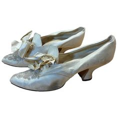 a pair of silver shoes with bows on them