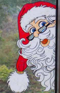 a stained glass window with santa clause on it's face and glasses in his mouth