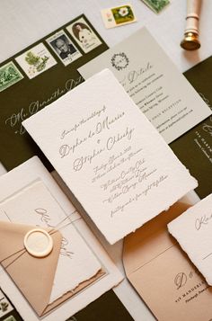 the wedding stationery is laid out on top of each other, including envelopes and cards