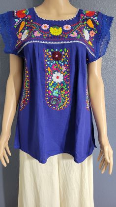 a mannequin wearing a blue top with colorful flowers on it