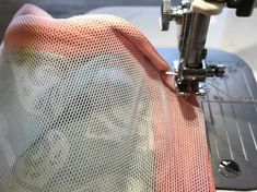 a close up of a sewing machine with an orange and white cloth on it's side