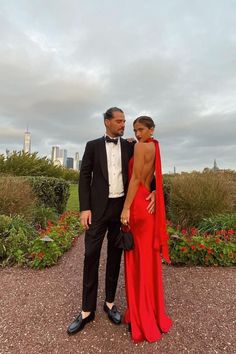 Un couple élégant pose dans un jardin avec des gratte-ciel en arrière-plan. Red Wedding Guest Dresses, Wedding Guest Outfit Inspiration, Summer Wedding Guest Dress, Black Tie Wedding Guest Dress, Spring Wedding Guest, Spring Wedding Guest Dress, Black Tie Wedding Guests, Dress Code Wedding, Summer Wedding Guest