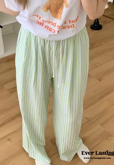 Indulge in the perfect blend of comfort and style with Ever Lasting's Candy Stripe Long Pajama Pants. These charming pants feature a delightful candy stripe pattern that adds a playful touch to your loungewear collection. Crafted from soft, breathable fabric, they ensure a cozy and comfortable fit, ideal for relaxing at home or enjoying a restful night's sleep. The elastic waistband provides a secure yet flexible fit, allowing for ease of movement and all-day comfort. Elevate your relaxation rou Casual Sleepwear With Vertical Stripes And Relaxed Fit, Casual Relaxed Fit Vertical Stripes Sleepwear, Striped Wide Leg Loungewear Bottoms, Casual Striped Bottoms For Loungewear, Trendy Striped Pants For Loungewear, Casual Vertical Stripes Bottoms For Loungewear, Striped Trousers For Loungewear, Striped Relaxed Fit Bottoms For Pajama Party, Casual Striped Lounging Bottoms