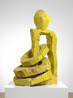 a yellow sculpture sitting on top of a white pedestal