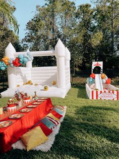 an inflatable castle is set up for a party with red and gold decorations