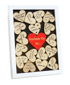 a heart - shaped wooden plaque with writing on it and hearts scattered around the frame