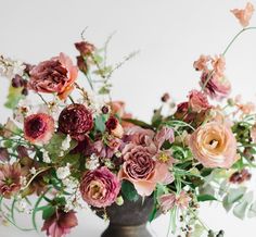 a vase filled with lots of flowers on top of a table