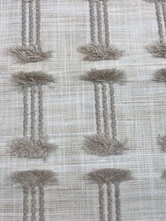 an upholstered piece of fabric with fringes on it