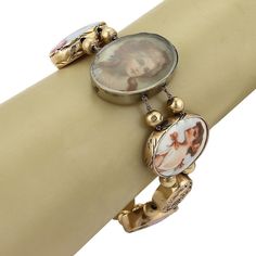 "This is a gorgeous antique bracelet, from the 1930s, it is crafted from solid 14k yellow gold featuring 8 oval shape links in assorted size, three with embossed floral design and is adorned with sapphire, emerald and diamond, five of the oval frame links are with handpainted porcelain cameo of 16th Century women in various dress style. Each oval link is separated by two gold balls on a double chain which fastens with a push in clasp with latch for added security. Metal: 14k yellow gold Hallmark Vintage Gold Rosary Bracelet Gift, Vintage Gold Rosary Bracelet As A Gift, Vintage Gold Rosary Bracelet For Gift, Vintage Adjustable Oval Link Bracelets, Antique Oval Gold Bracelet, Vintage Adjustable Bracelet With Oval Links, Vintage Adjustable Cameo Bracelet, Antique Oval Cameo Bracelet, Adjustable Vintage Cameo Bracelet