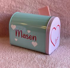 a green mailbox with hearts and the word masen written in red on it