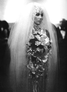 an old photo of a woman in a wedding dress with flowers on her head and veil