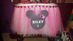 a pink and black tulle skirt with a mickey mouse head on the bottom that says riley 1