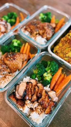 four plastic containers filled with food on top of a wooden table next to broccoli and carrots