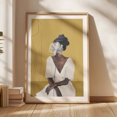 a framed photograph of a woman with flowers in her hair sitting on a table next to books