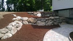 a stone wall next to a brick walkway