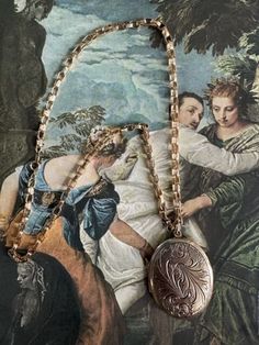 "Vintage Large Gold Tone Metal Locket Pendant. This locket is hinged and opens up to two sides where photos can be placed. It measure1 3/4\" in width and and  2 3/16\" in length. It is a gold tone metal with large scrolling leaf designs engraved on both sides. The chunky change is 24\" in length. It has a Napier stamp on the oval tag that the clasp attaches to for closure. The chain has chunky links with a dimpled texture. It is a high end quality chain. It has a round spring ring clasp. The cha Locket Vintage, Large Locket, Locket Necklace Vintage, Clothing Board, Necklace Locket, Vintage Locket, Character Clothing, Leaf Designs, Oval Locket