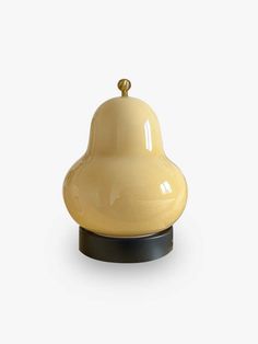 a small yellow bell on a black stand