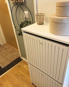 a white cabinet sitting on top of a hard wood floor