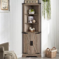 a wooden cabinet sitting in a living room next to a chair and potted plant