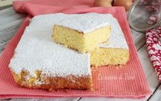 two pieces of cake sitting on top of a red towel next to an egg in the background