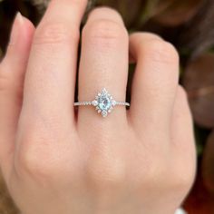 a woman's hand with a diamond ring on it