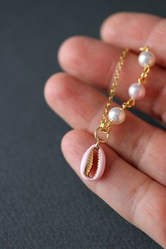 This dainty summer beach style necklace was made of delicate light pink enamel cowrie shell gold tone stainless steel charm, Swarovski crystal pearl coated white and light pink 6 mm beads, gold tone steel jumping rings and gold tone stainless steel chain with gold tone lobster claw. The chain is from lead free & nickel free metal. The length of necklace is 47.5 cm or 18.5 inches. Shell bead size: 9x13 mm. Other necklaces of my shop you can see here: https://www.etsy.com/shop/NaTavelli?sectio Handmade Pink Strand Jewelry, Dainty Pearl Necklaces For The Beach, Dainty Pearl Necklace For Beach, Pink Shell-shaped Necklace For Beach, Pink Dangle Jewelry For Vacation, Dainty Pink Jewelry For Beach, Summer Gift Pink Shell Necklace, Pink Shell Jewelry For Summer, Pink Shell-shaped Jewelry For Summer