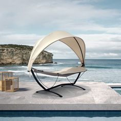 a chair sitting on top of a cement slab next to the ocean